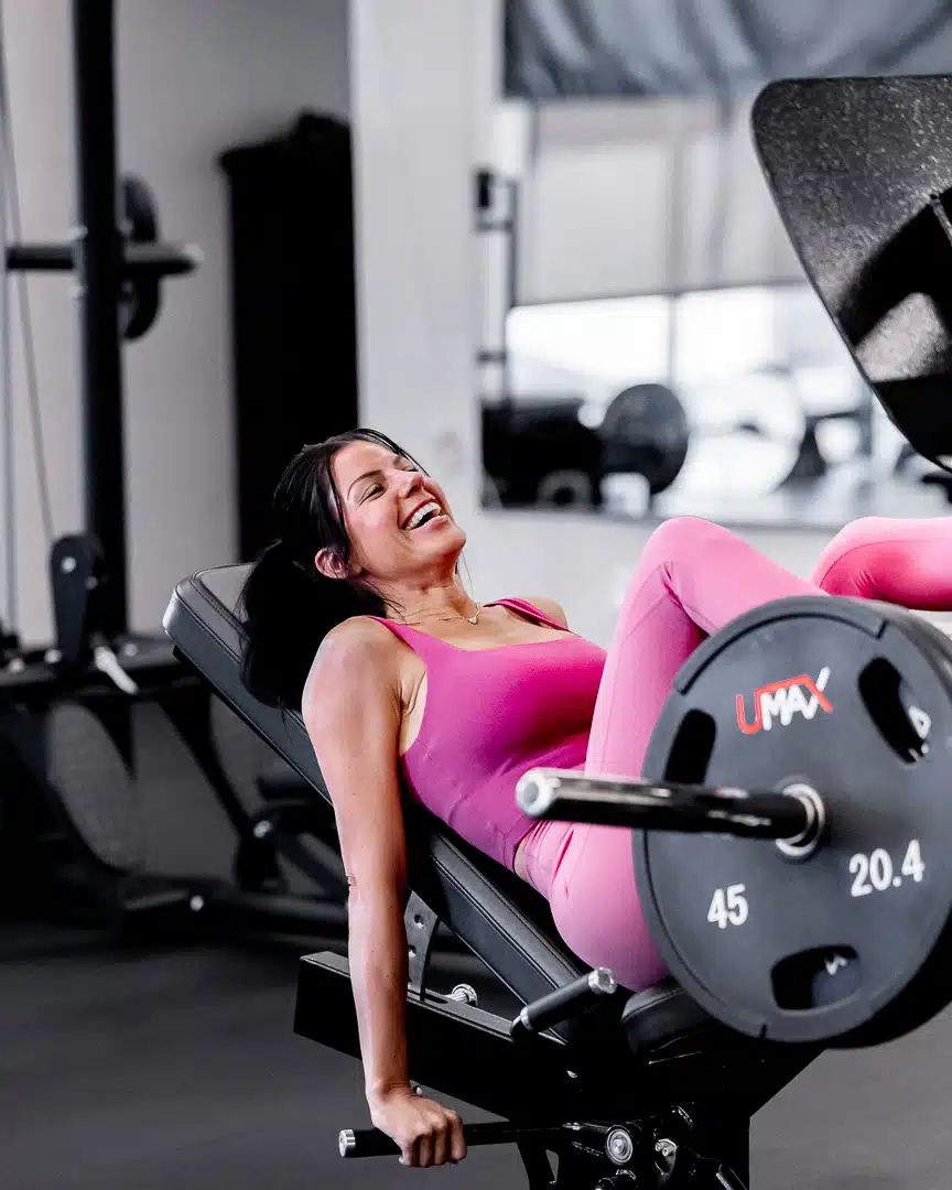 member pushing through leg press smiling